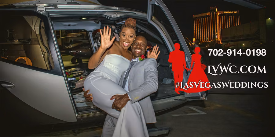 Newlyweds celebrating beside their helicopter with the Las Vegas Strip and Mandalay Bay behind them