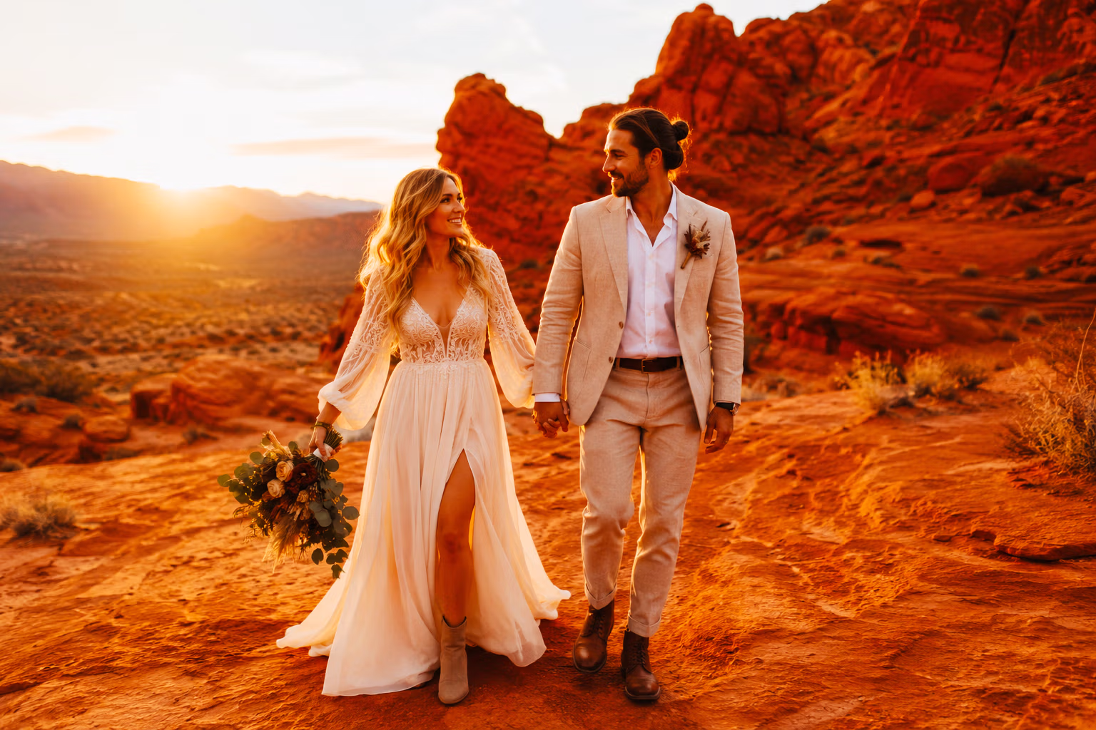 Couple dressed for a Las Vegas desert wedding against red rock at golden hour — LVWC.com attire guide